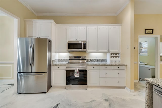 kitchen with stainless steel appliances, ornamental molding, light stone countertops, and white cabinets