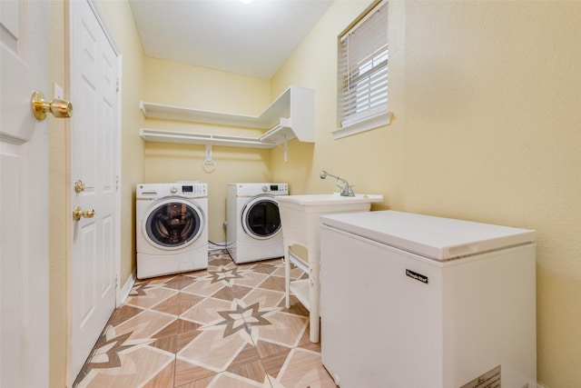 laundry area featuring light parquet flooring, sink, and washer and dryer