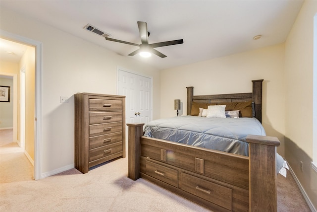 bedroom featuring ceiling fan, light colored carpet, and a closet