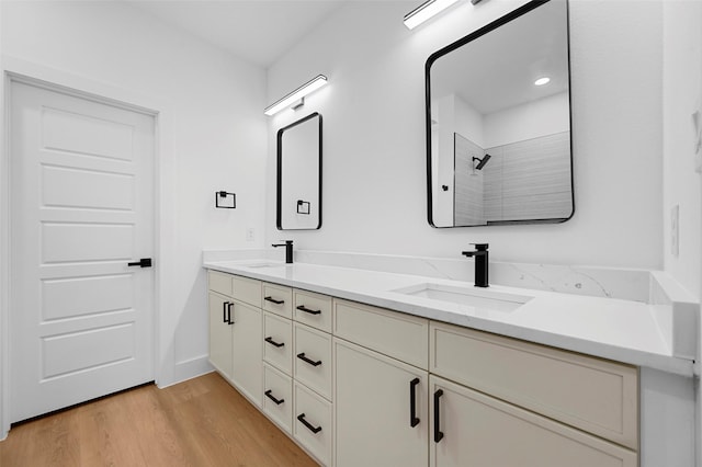 bathroom with hardwood / wood-style flooring, vanity, and a shower