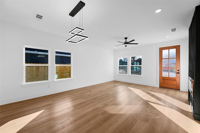 unfurnished living room with ceiling fan and light wood-type flooring