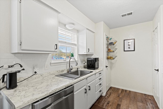 kitchen with sink, dark hardwood / wood-style flooring, dishwasher, white cabinets, and backsplash