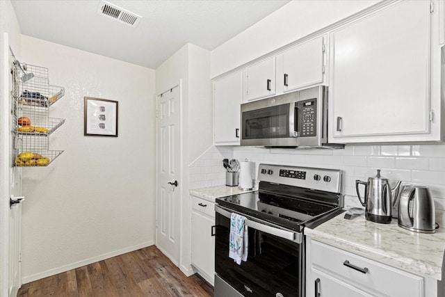 kitchen featuring appliances with stainless steel finishes, backsplash, light stone counters, white cabinets, and dark hardwood / wood-style flooring