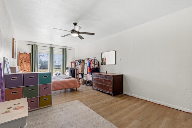 bedroom featuring ceiling fan, wood-type flooring, and a textured ceiling