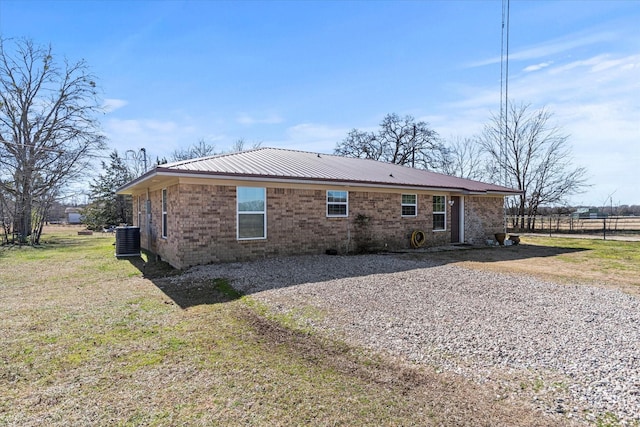 rear view of property featuring a yard and central AC unit