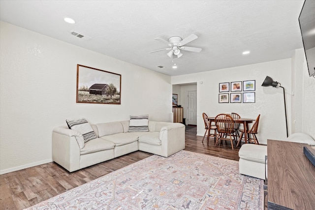 living room featuring ceiling fan and hardwood / wood-style floors