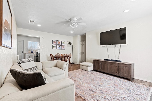 living room with ceiling fan and light hardwood / wood-style floors