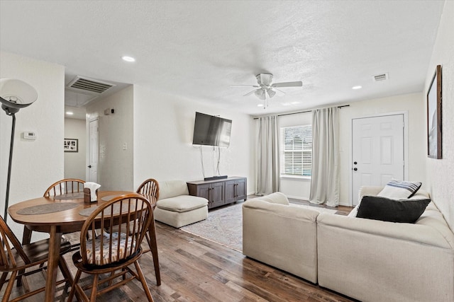 living room featuring ceiling fan, wood-type flooring, and a textured ceiling