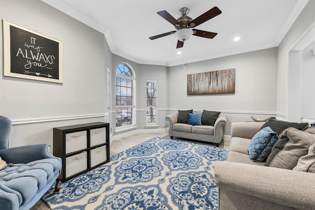 living room with light hardwood / wood-style flooring, ornamental molding, and ceiling fan