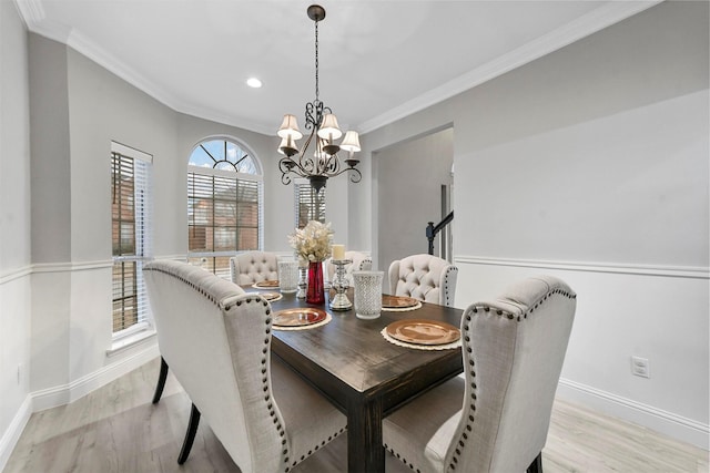 dining area with ornamental molding, a chandelier, and light hardwood / wood-style flooring