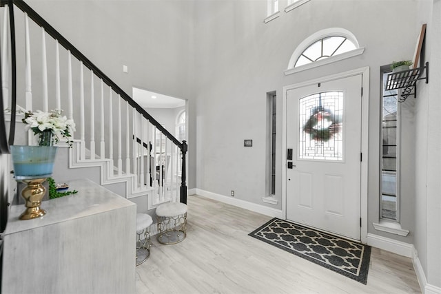 entrance foyer with a high ceiling and light wood-type flooring