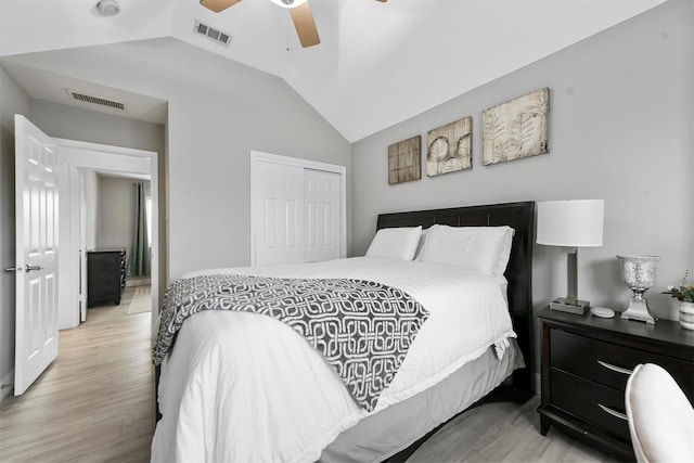 bedroom with lofted ceiling, a closet, ceiling fan, and light wood-type flooring