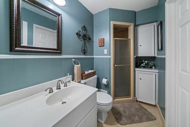 bathroom featuring vanity, tile patterned floors, a textured ceiling, and a shower with shower door