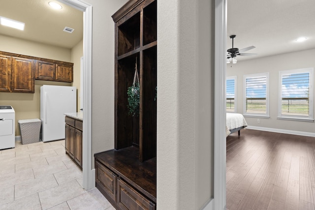 mudroom with visible vents, a ceiling fan, light tile patterned flooring, washer / dryer, and baseboards