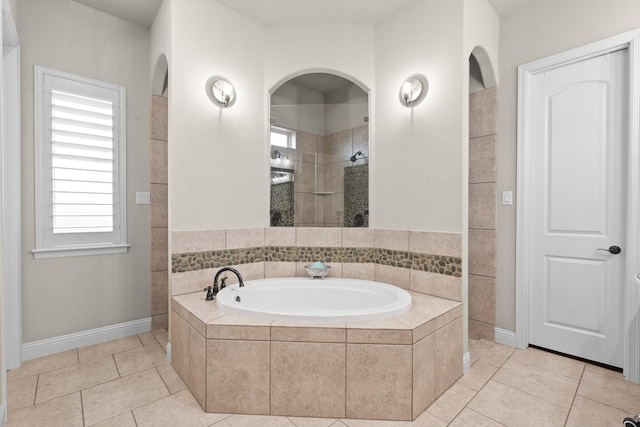 bathroom featuring tiled shower, a bath, and tile patterned floors