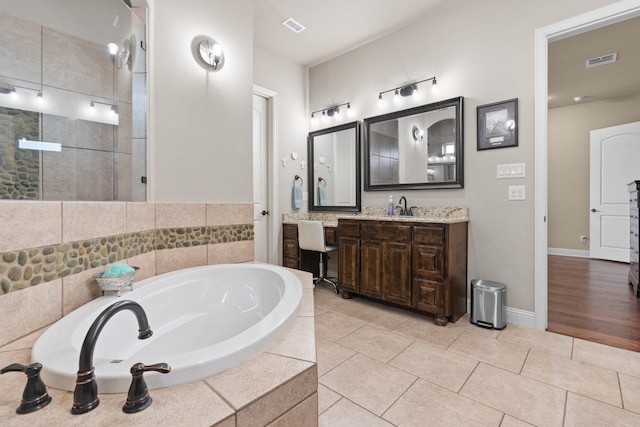 bathroom with a bath, tile patterned flooring, vanity, and visible vents