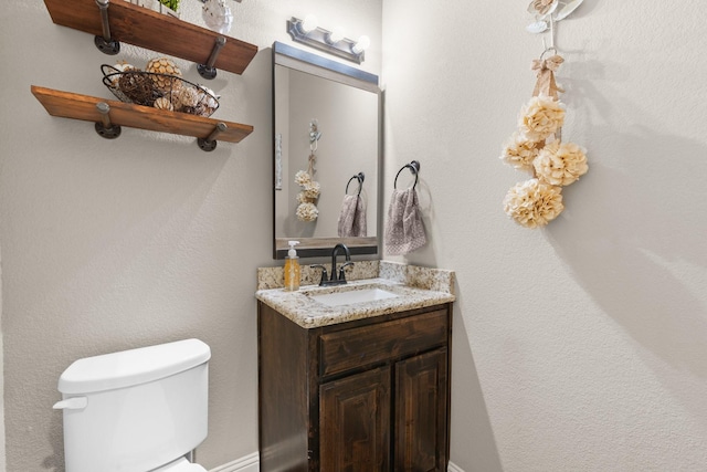 half bathroom featuring vanity and toilet