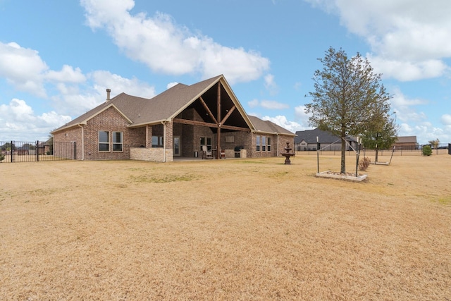 rear view of house with a patio area, fence, a lawn, and brick siding