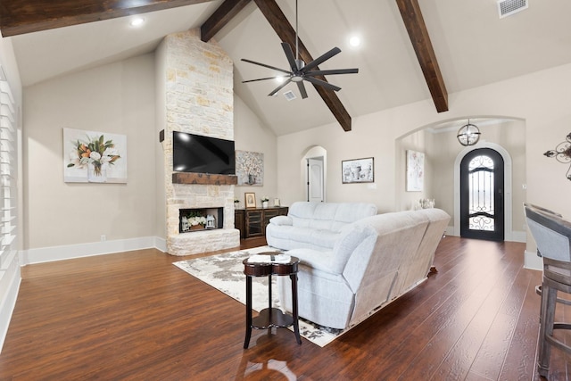 living room featuring visible vents, a fireplace, arched walkways, and dark wood-style flooring