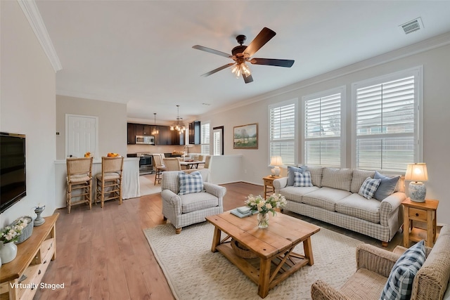 living room featuring crown molding, ceiling fan, and light wood-type flooring