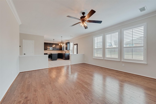 unfurnished living room featuring ornamental molding, ceiling fan, and light wood-type flooring