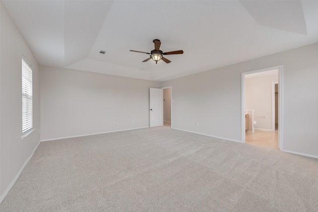 unfurnished room with light carpet, ceiling fan, and a tray ceiling