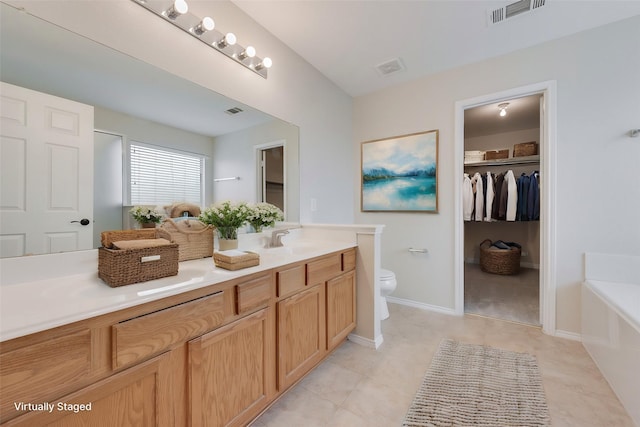 bathroom featuring vanity, toilet, and a washtub