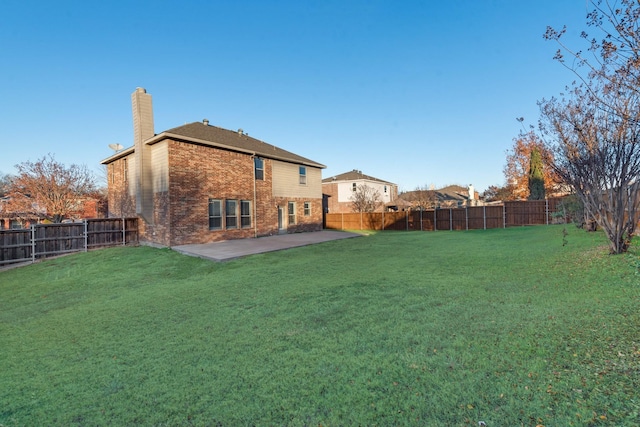 back of property with a yard and a patio area