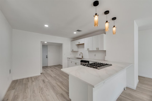 kitchen with white cabinetry, light hardwood / wood-style flooring, kitchen peninsula, dishwasher, and pendant lighting