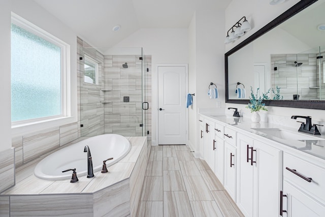 bathroom featuring vanity, vaulted ceiling, and shower with separate bathtub