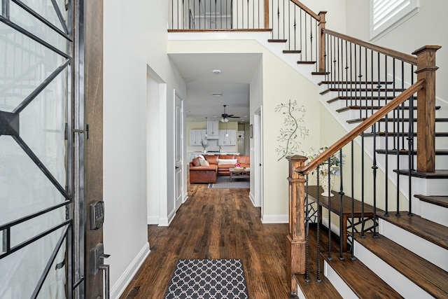 entrance foyer with ceiling fan, dark hardwood / wood-style flooring, and a high ceiling