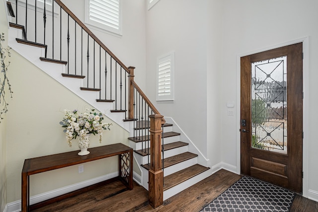 foyer featuring dark hardwood / wood-style flooring and a towering ceiling