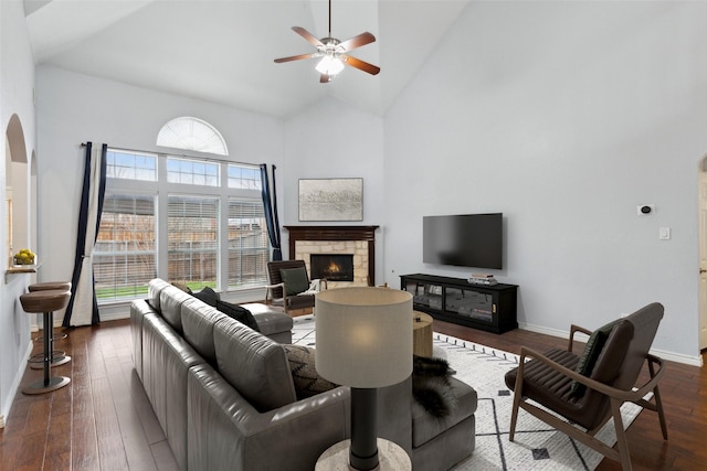 living room with hardwood / wood-style flooring, ceiling fan, and high vaulted ceiling