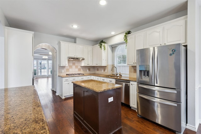 kitchen featuring sink, white cabinetry, tasteful backsplash, stainless steel appliances, and light stone countertops