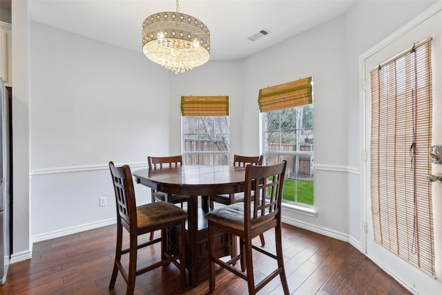 dining area featuring dark hardwood / wood-style flooring and a notable chandelier