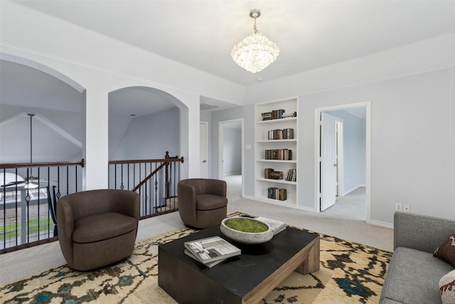 living room featuring light carpet, a chandelier, and built in shelves