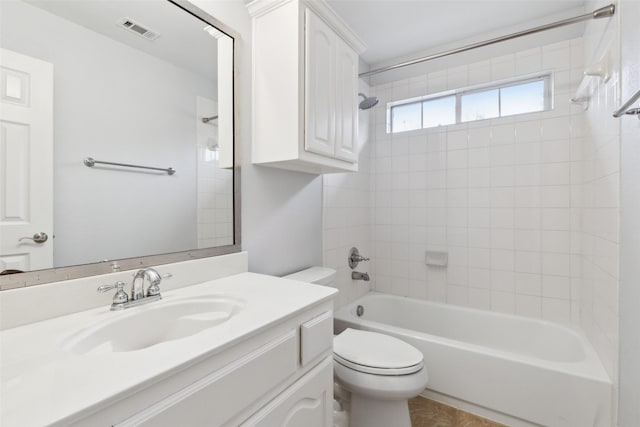 full bathroom featuring tiled shower / bath, vanity, and toilet