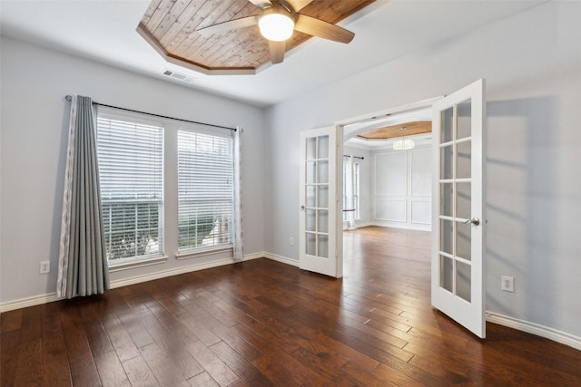 spare room with french doors, ceiling fan, a tray ceiling, and dark hardwood / wood-style flooring