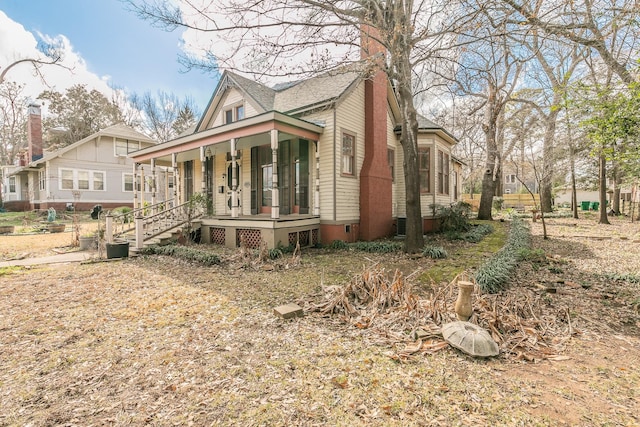 view of side of home featuring covered porch