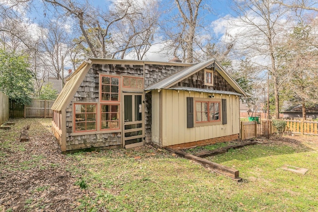 back of property with a yard and an outdoor structure