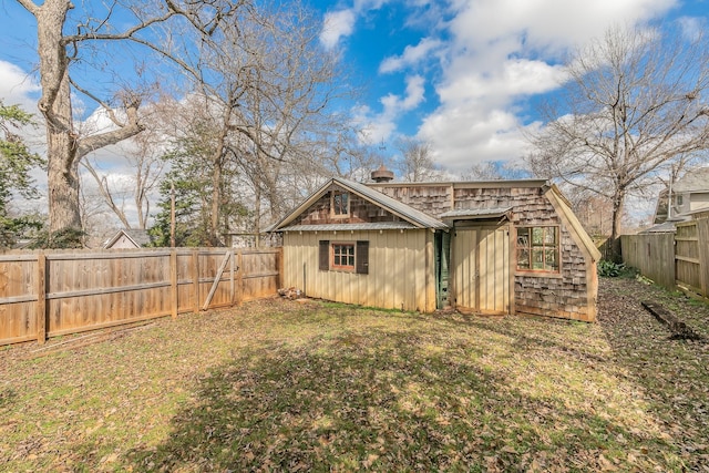 rear view of house with a yard and an outdoor structure