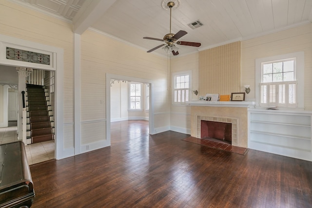 unfurnished living room with hardwood / wood-style floors, crown molding, and a tile fireplace