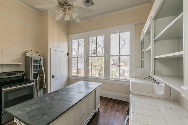 kitchen featuring dark wood-type flooring, ceiling fan, ornamental molding, and electric range