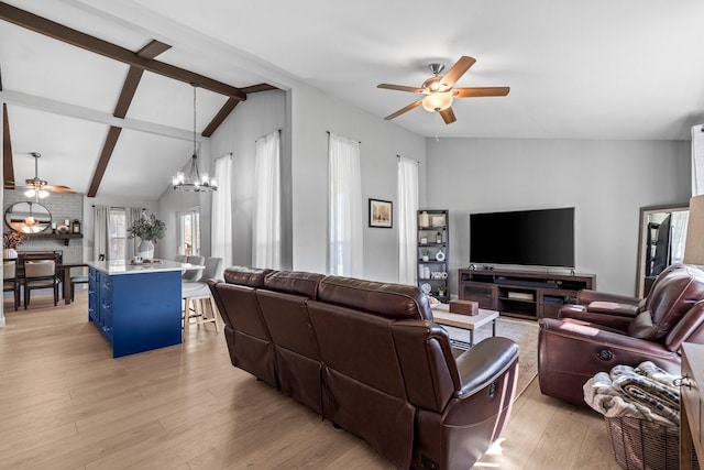 living room with ceiling fan with notable chandelier, light hardwood / wood-style floors, and lofted ceiling with beams