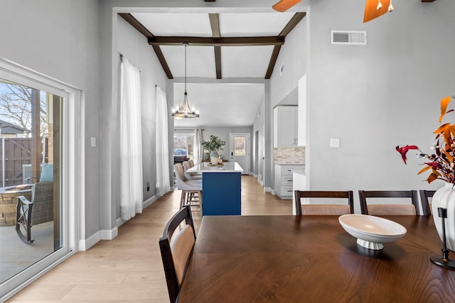 dining area featuring a notable chandelier, beam ceiling, light hardwood / wood-style flooring, and high vaulted ceiling