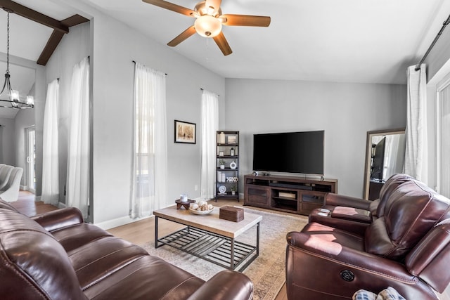 living room with vaulted ceiling, ceiling fan with notable chandelier, and light hardwood / wood-style flooring