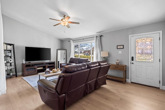 living room featuring ceiling fan, vaulted ceiling, and light wood-type flooring