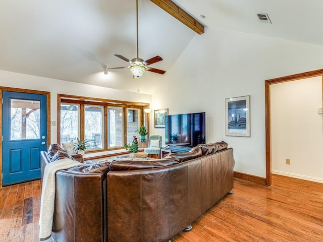 living area featuring high vaulted ceiling, light wood-style floors, baseboards, and beam ceiling