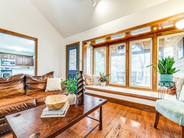 living area with vaulted ceiling and hardwood / wood-style floors