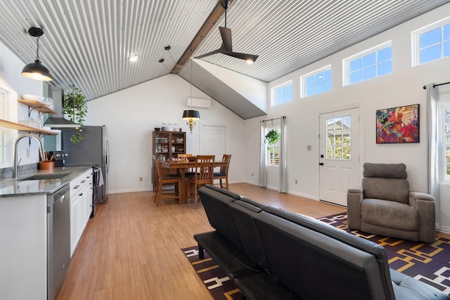 living room featuring sink, high vaulted ceiling, a wall mounted AC, and light wood-type flooring